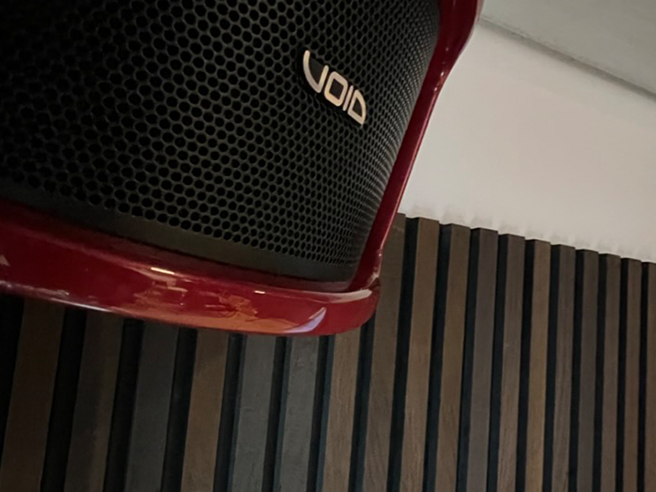 Röd högtalare mot panelvägg av ek